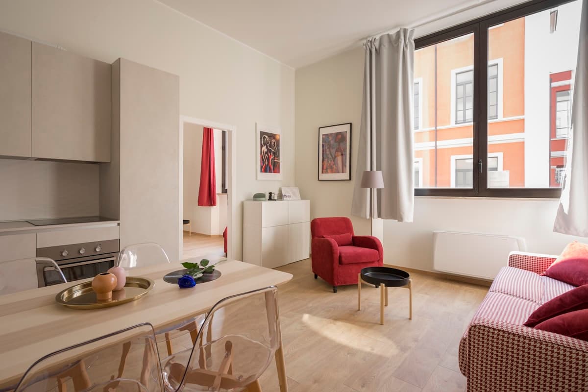 One bedroom apartment living and dining area with a doorway to a separate bedroom — representative photo
